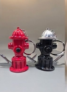 Two fire hydrant keychains, one red and one black, displayed side-by-side on a neutral gray background. alternate view