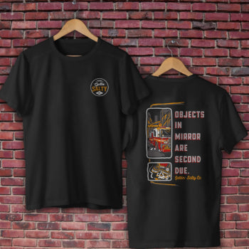 Black t-shirt with graphic design on a brick wall background alternate view