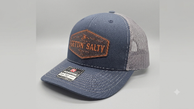 A navy blue and gray trucker hat with a brown 'Gettin' Salty' patch on the front, shown on a neutral gray background.
