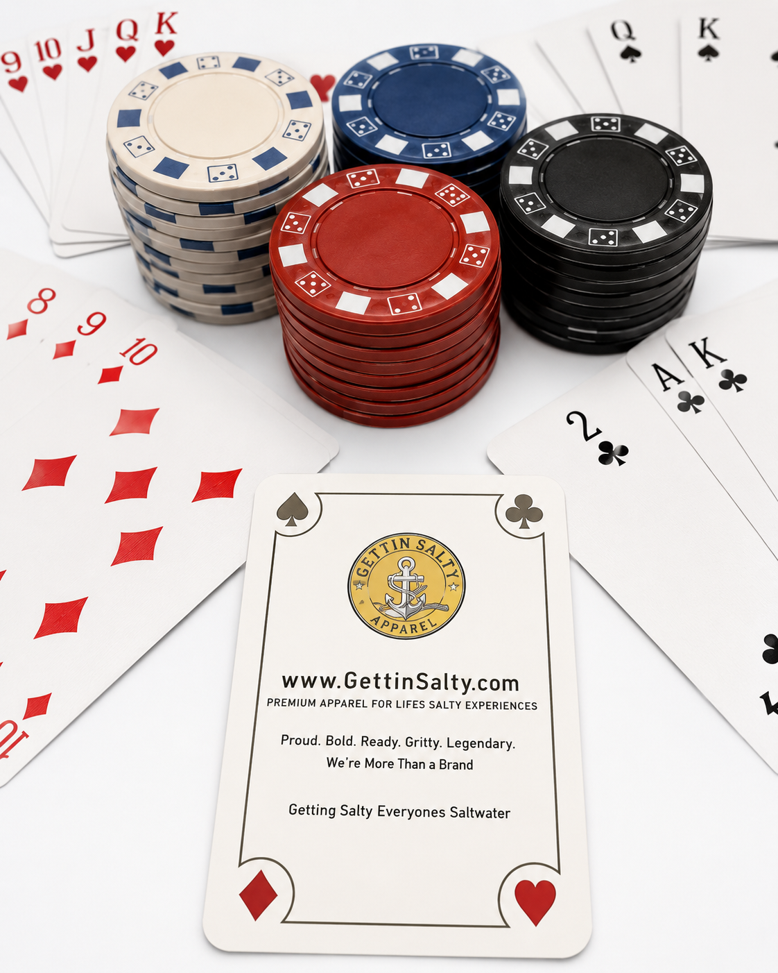 A styled flat-lay of playing cards and poker chips with a prominent Getting Salty branded card in the foreground. The scene includes stacks of white, blue, red, and black chips, scattered face-up cards, and a white card displaying the Getting Salty logo and website.