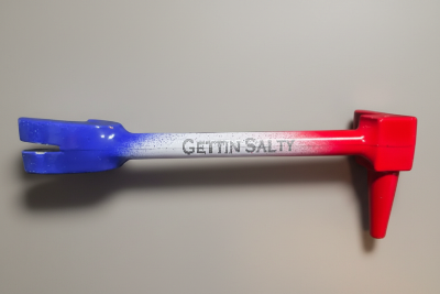 A novelty Halligan tool with a red-to-blue gradient handle and the text 'GETTIN SALTY' printed on the side, resting on a dark gray surface.