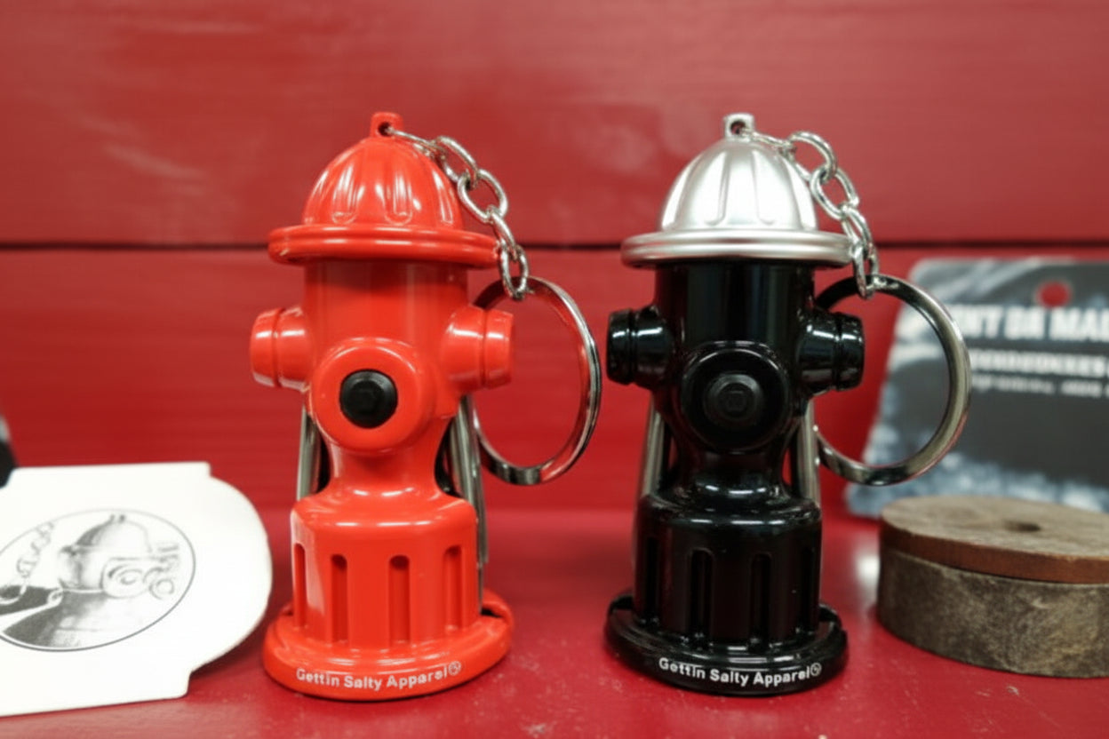 Two fire hydrant keychains, one red and one black with silver top, on a red background.