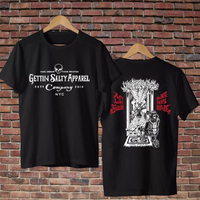 Black t-shirt with graphic designs and text on a brick wall background
