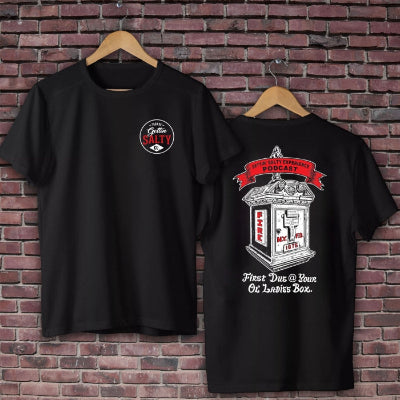 Black t-shirt with graphic designs on a brick wall background