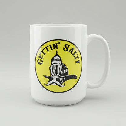 White mug with yellow logo featuring text 'GETTIN' SALTY' on a reflective surface.