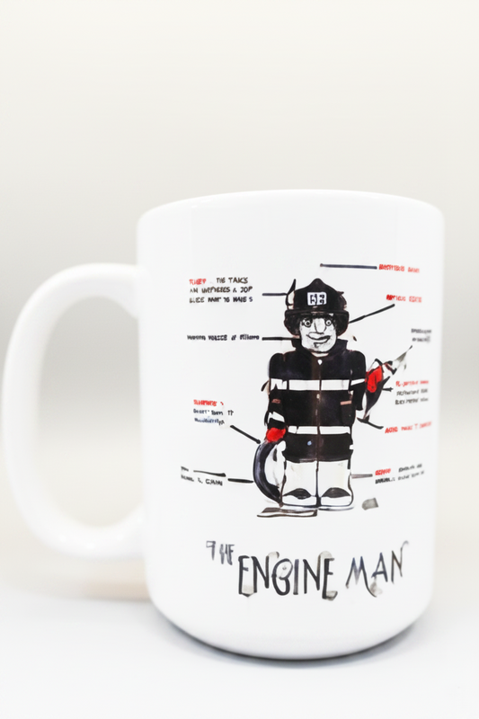 A white ceramic coffee mug featuring a black and red cartoon illustration of a firefighter with text labels and the words 'THE ENGINE MAN' printed below, set against a plain light gray background.