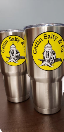 Two stainless steel tumblers with a yellow label on a gray background