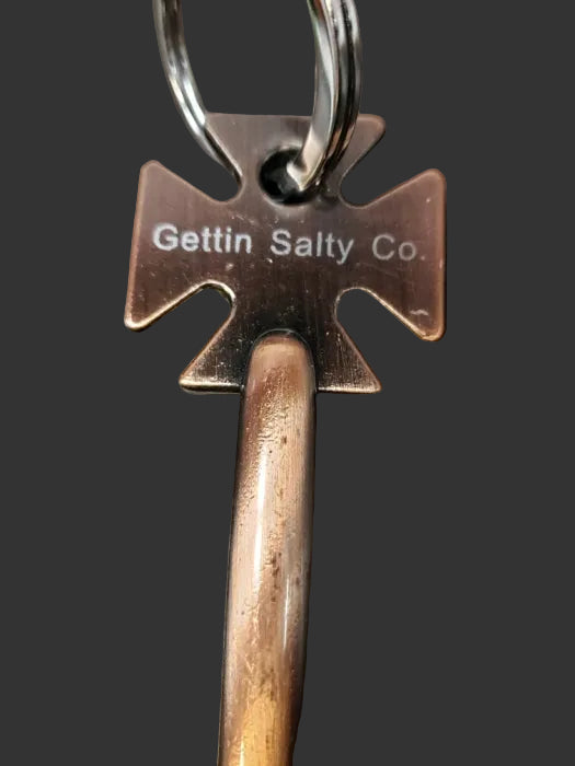 Metal keychain with 'Gettin Salty Co.' branding on a dark surface