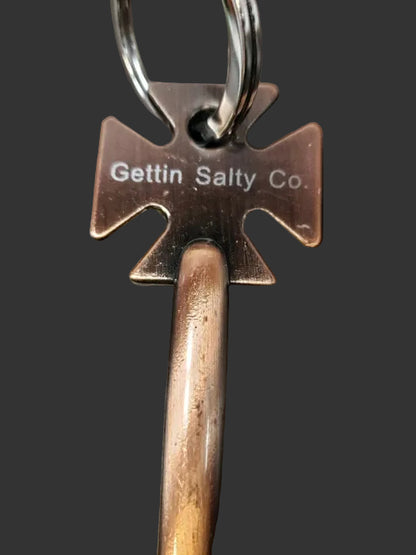 Metal keychain with 'Gettin Salty Co.' branding on a dark surface