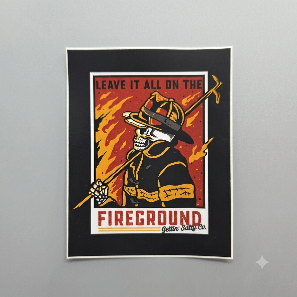 A framed art print featuring a stylized firefighter skeleton holding a hose, with flames in the background and the text 'LEAVE IT ALL ON THE FIREGROUND Gettin' Sandy Co.' on a light gray wall.